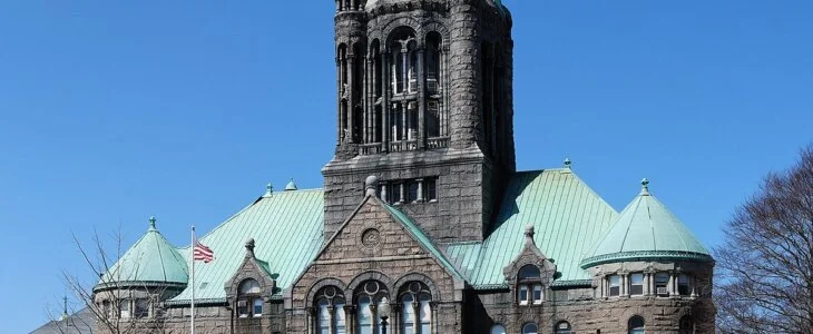 Stone building with central tower and green copper roof